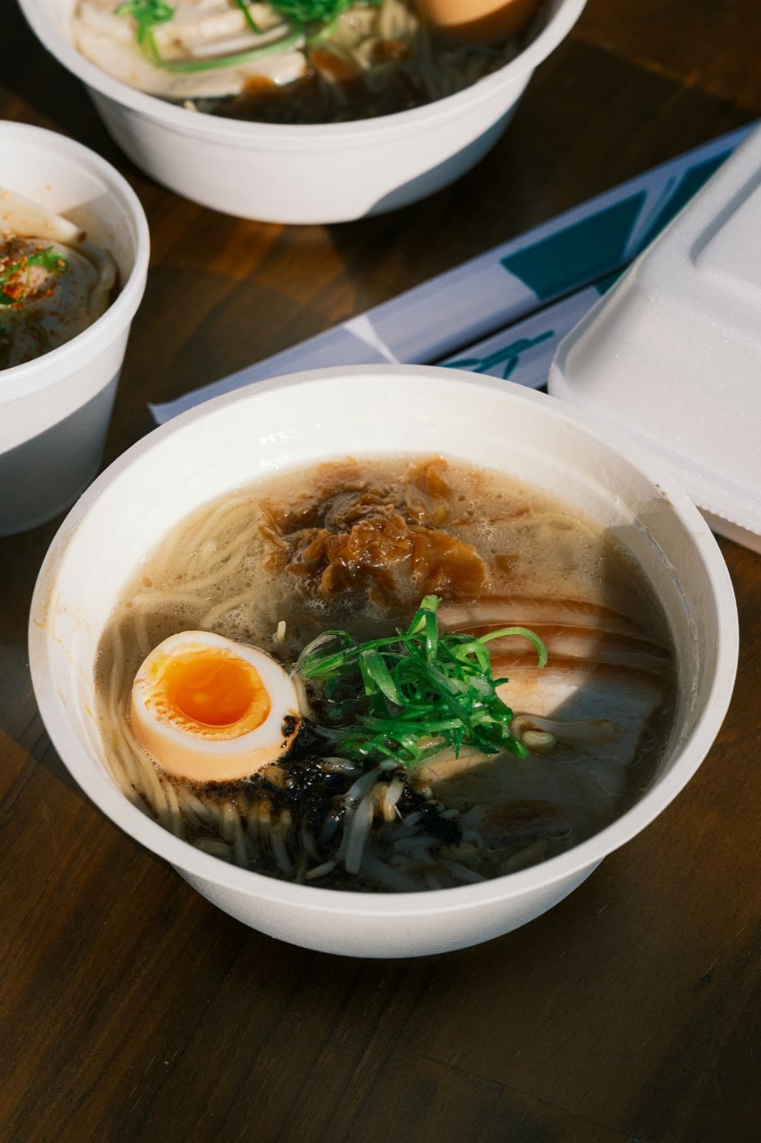 Steaming ramen bowl with rich broth in soft evening light.