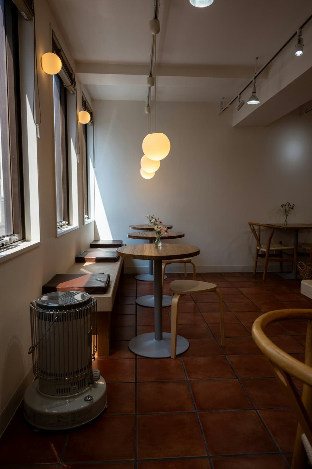 Sunlit cafe interior with warm wood tables and natural light.